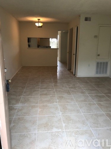 A room with tile flooring and a mirror on the wall.