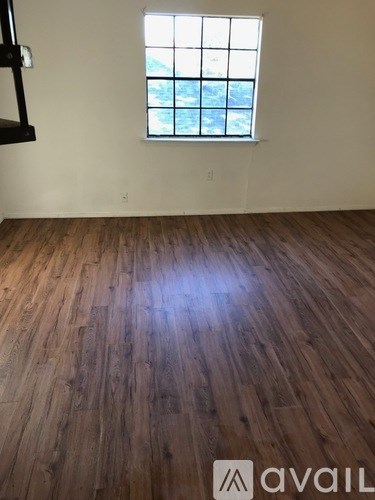 A room with wooden flooring and a window.