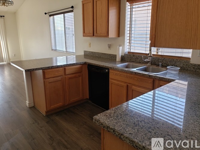A kitchen with wooden cabinets and granite countertops.