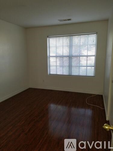A room with a window and wooden floors.