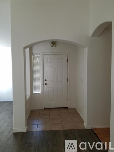 A room with a white door and a brown rug on the floor.