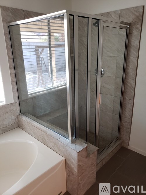 A bathroom with a glass shower door and a white sink.