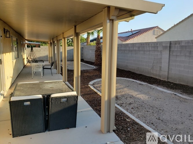 A patio with a table and chairs under a roof.