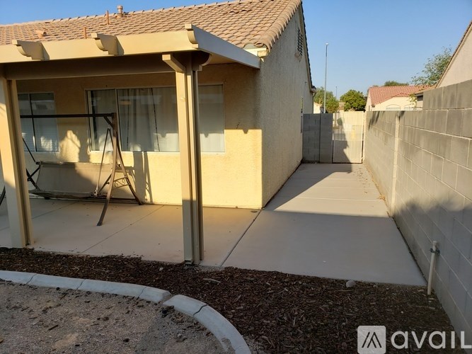 A small house with a patio and a swing set.