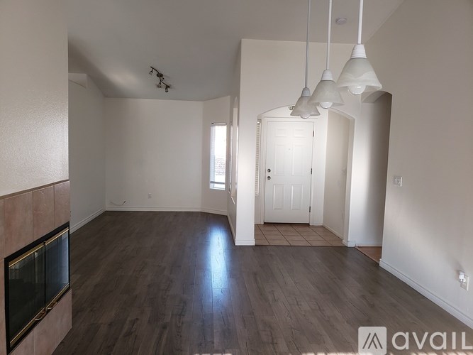 A living room with a fireplace and a door leading to another room.