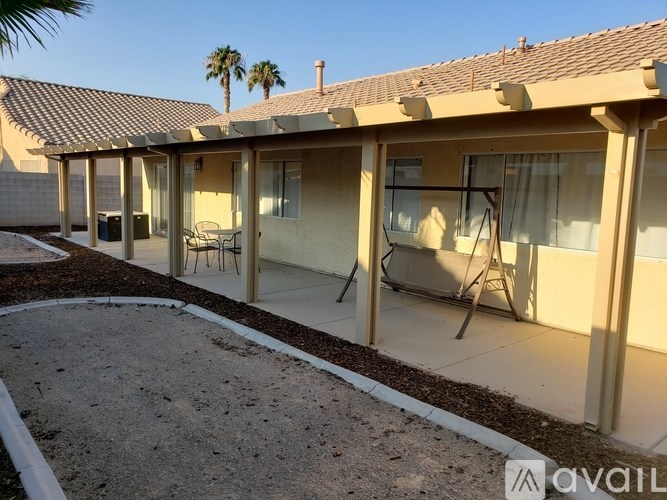 A house with a patio and a pool in front.