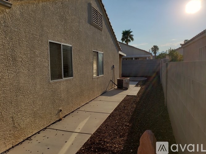 A sunny day with a building and a fence in the foreground.