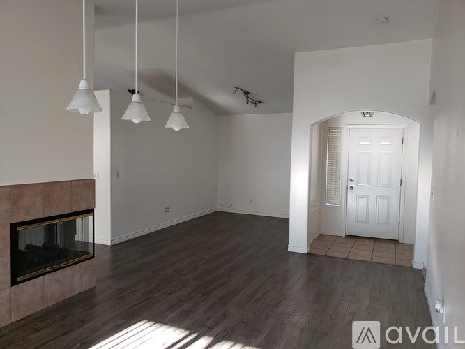 A living room with a fireplace and a doorway leading to another room.