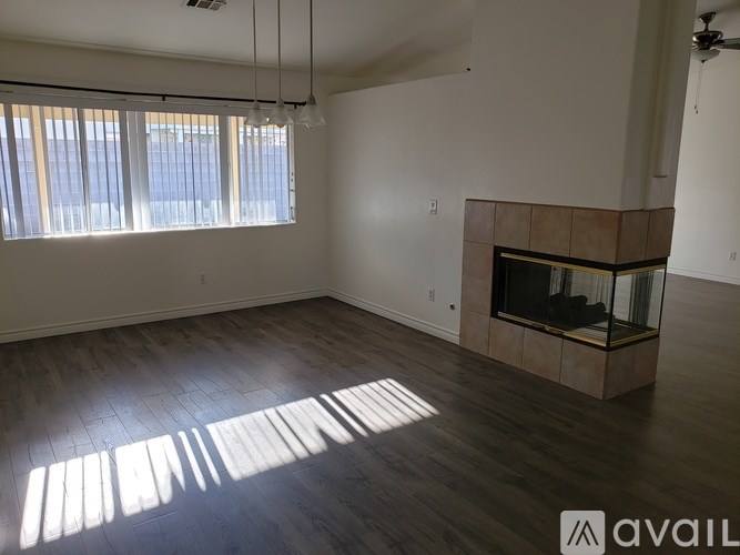 A spacious living room with a fireplace and large windows.