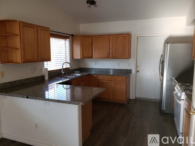 A kitchen with wooden cabinets and granite countertops.