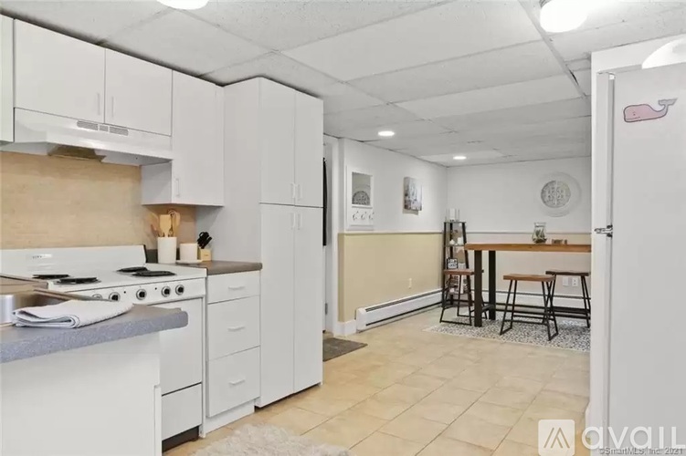A kitchen with white appliances and cabinets.