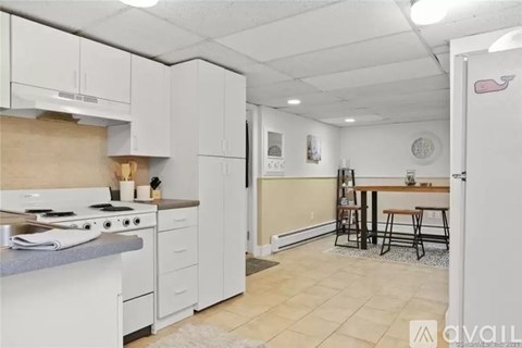 A kitchen with white appliances and cabinets.