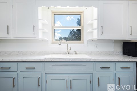 A kitchen with blue cabinets and a window.