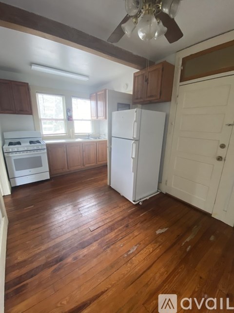A kitchen with wooden floors and white appliances.
