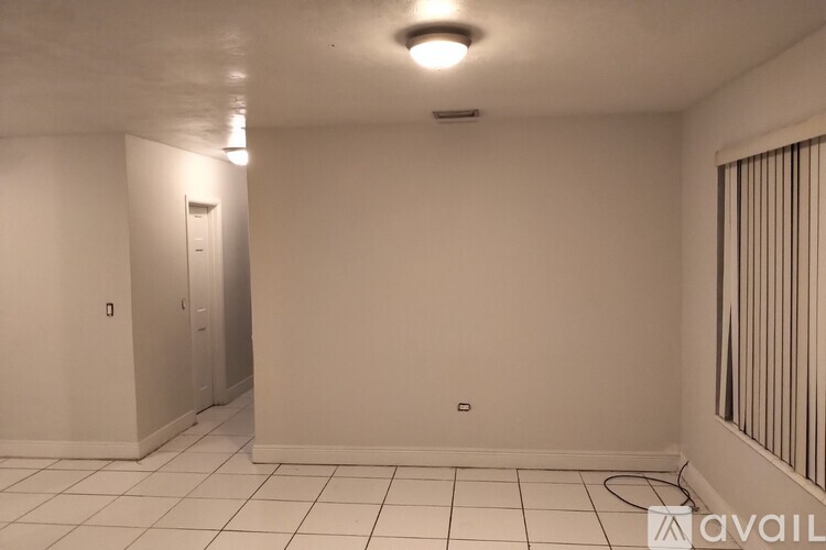 A white room with a door and a window with bars.