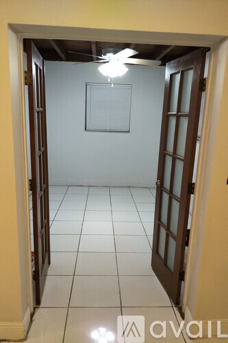 A room with a ceiling fan and a door.