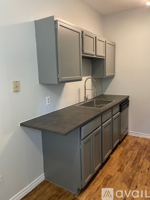 A kitchen with grey cabinets and a counter top.