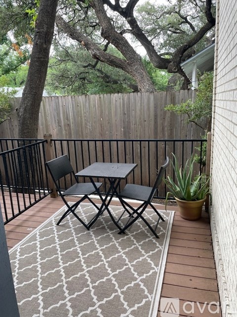 A small table and two chairs are on a patio.