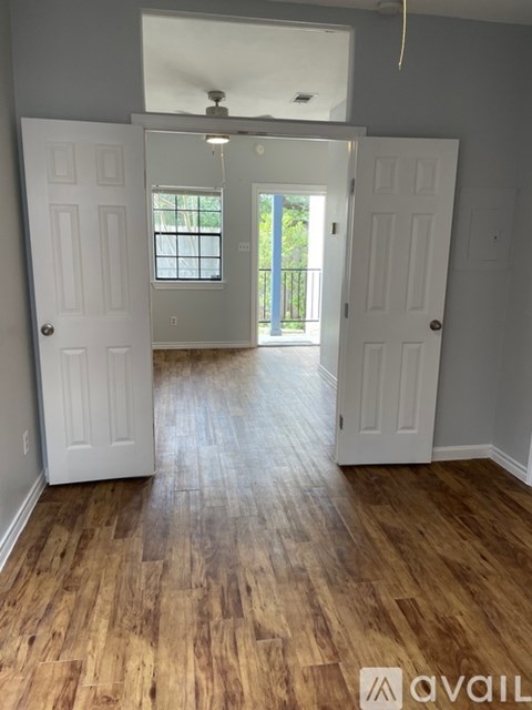 A room with wooden floors and two white doors.