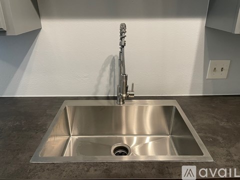 A modern kitchen sink with a chrome faucet.
