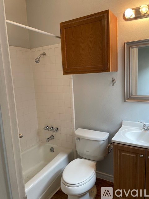 A white toilet sits next to a white bathtub in a bathroom.