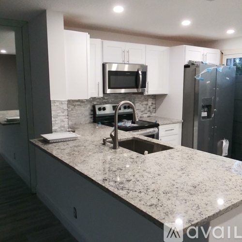 A kitchen with granite countertops and stainless steel appliances.