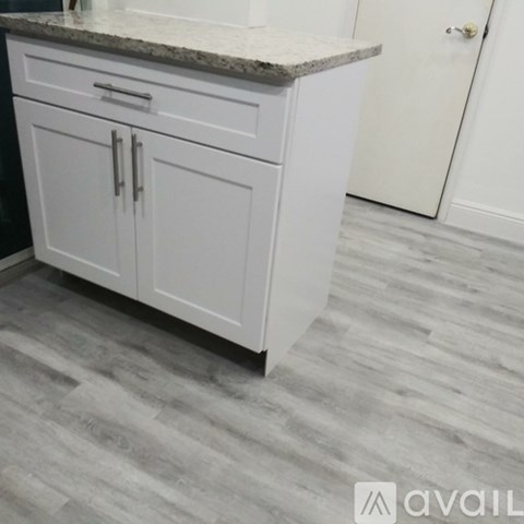 A kitchen with white cabinets and a granite countertop.