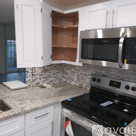 A kitchen with a stove, microwave, and cabinets.