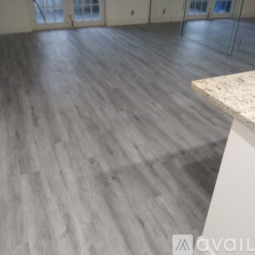 A room with a wooden floor and a marble countertop.