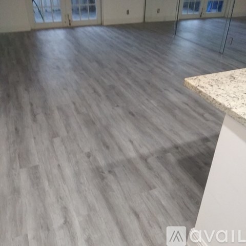 A room with a wooden floor and a marble countertop.