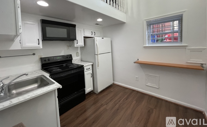 A kitchen with white cabinets and a black stove top oven.