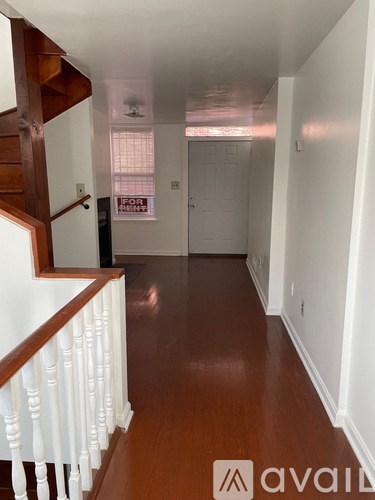 A hallway with wood floors and white railings.