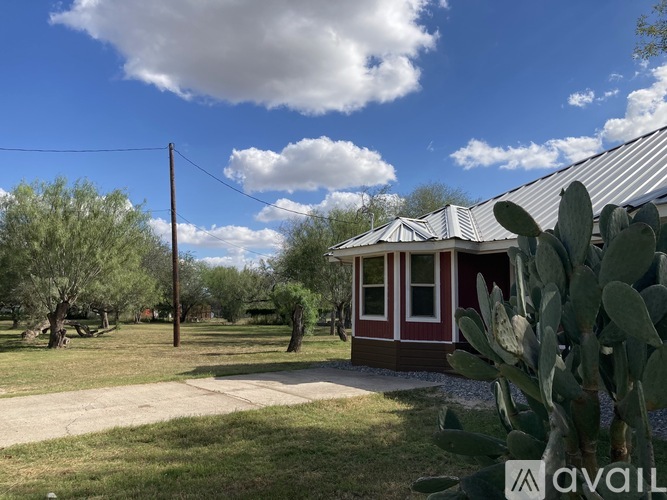 A house with a red door and a cactus in front.