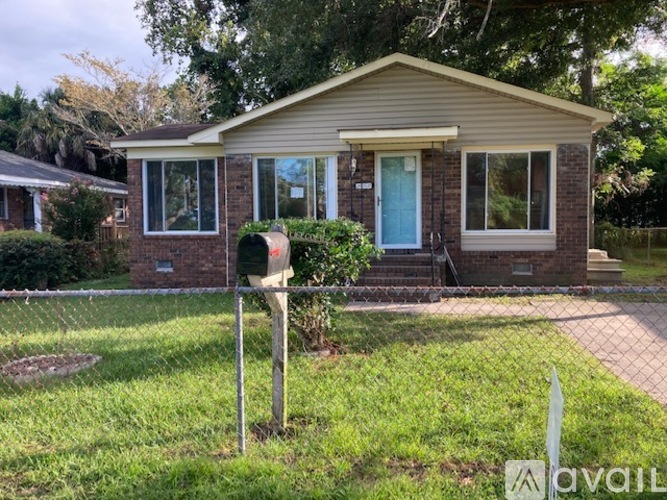 A house with a blue door and a mailbox on the lawn.