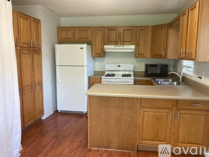 A kitchen with wooden cabinets and a white refrigerator.