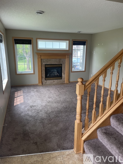 A living room with a fireplace and a staircase.