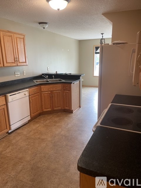 A kitchen with wooden cabinets and a black countertop.
