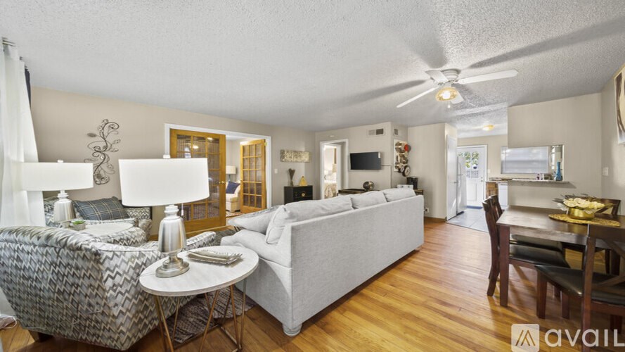 A living room with a grey couch, a white table, and a television.