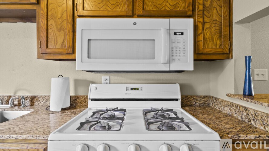 A white stove with a white microwave above it in a kitchen.