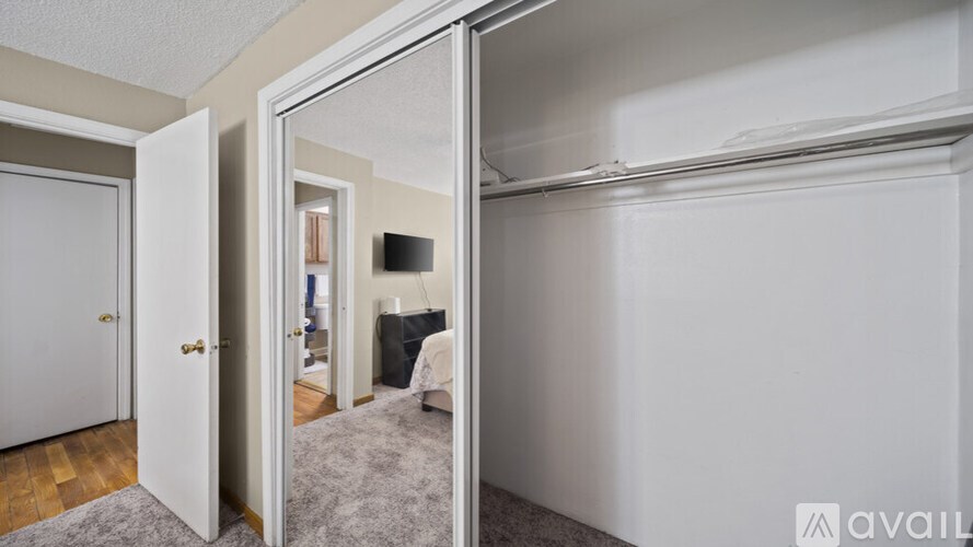 A bedroom with a bed and a dresser is visible through a glass door.