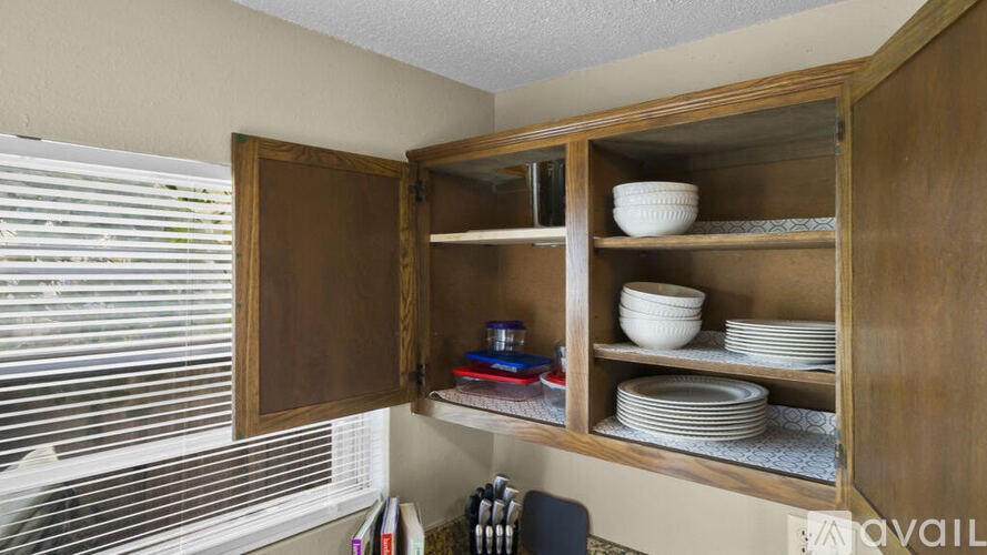 A kitchen cabinet with a bowl on the top shelf.
