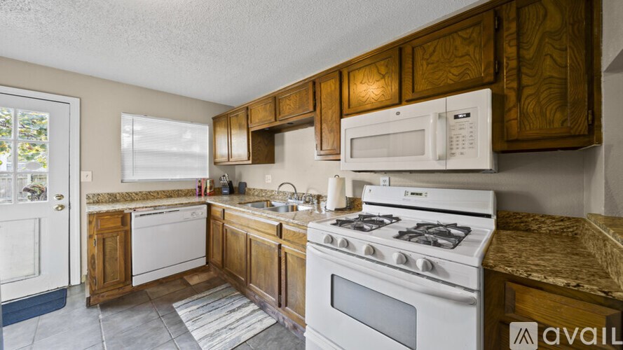 A kitchen with a white stove top oven and microwave above it.