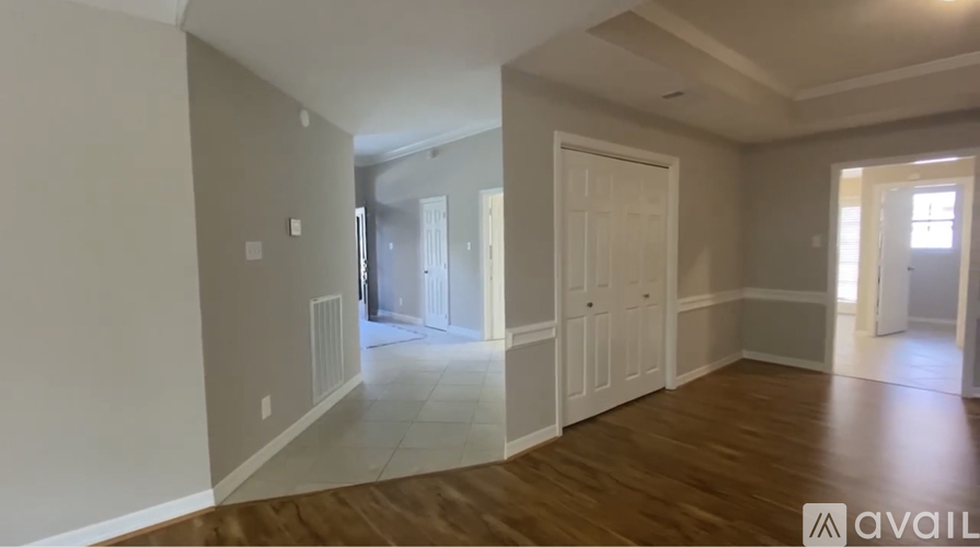 A spacious room with wooden floors and white walls.