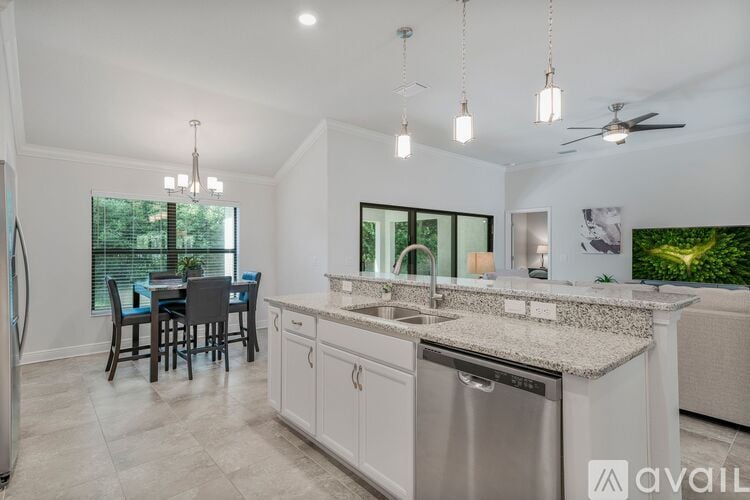 A modern kitchen with a dining table and chairs, a sink, and a refrigerator.