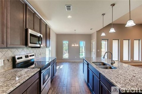 A kitchen with dark wood cabinets and granite countertops.