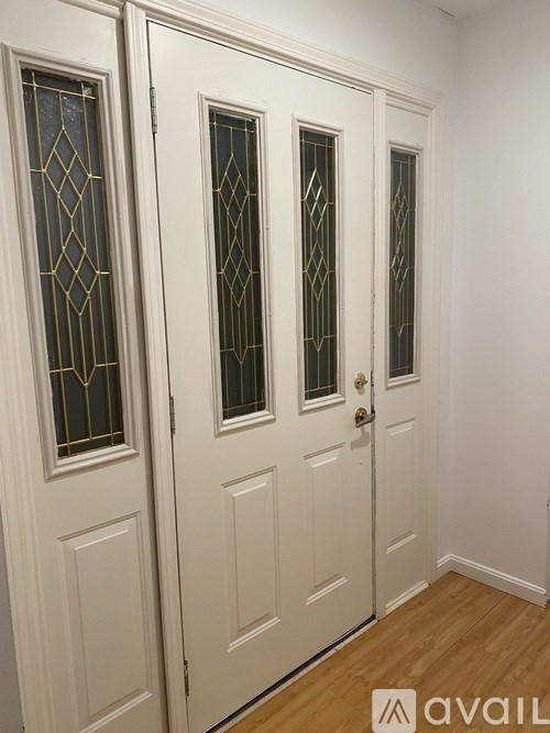 A white door with a glass panel and a gold handle.