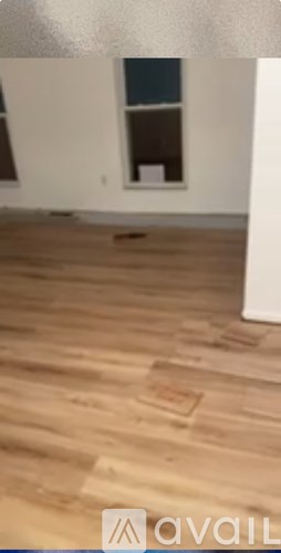 A room with wooden flooring and a window.