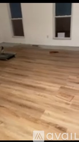 A room with wooden flooring and a window.