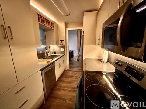 A modern kitchen with white cabinets and stainless steel appliances.
