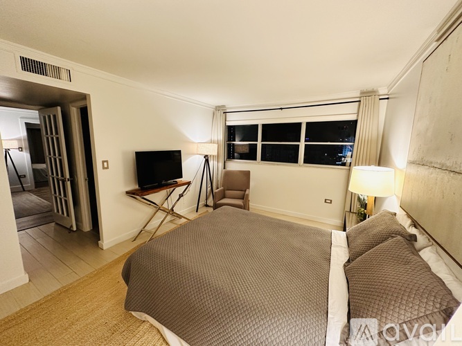 A bedroom with a large bed and a television.